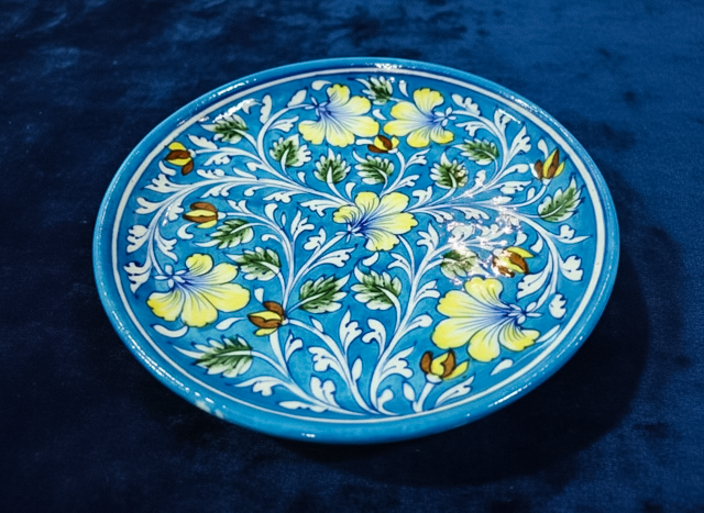 Blue Pottery Plate with hand painted stylized flowers with five scalloped yellow fan petals with vine Foliage